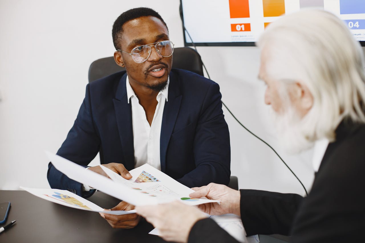 Two businessmen engaged in a meeting discussing charts and documents.